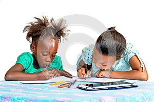 Two little African girls drawing with crayons at desk