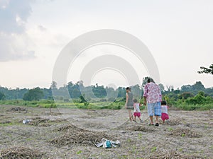 Two little baby girls together with their grandmother, and mother spending time outdoor at a natural open field