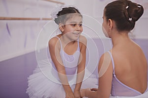 Two little ballerinas talking after dancing lesson