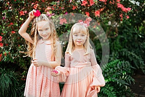 Two little beautiful sisters are walking and having fun in azaleas park