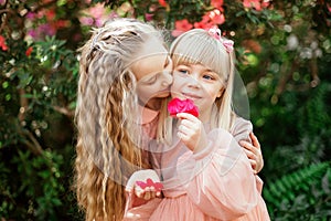 Two little beautiful sisters are walking and having fun in azaleas park