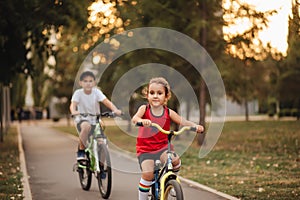 Two little boy and girl cyclists riding their bikes and enjoy having fun. Kid outdoors sport summer activity
