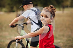 Two little boy and girl cyclists riding their bikes and enjoy having fun. Kid outdoors sport summer activity