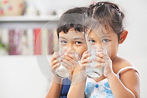 Two little boy and girl drinking milk