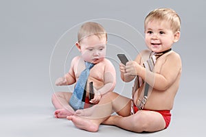 Two Little boy in tie play with cell phone