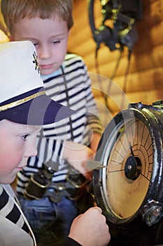 Two little boys ctand near ship endgine telegraph photo