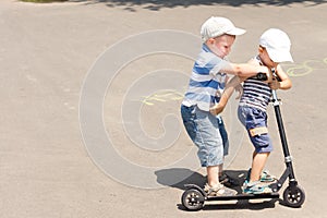 Two little boys enjoying a scooter ride