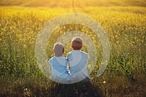 Two little boys friends hug each other on sunset summer. Brother love. Concept friendship. Rear view.