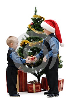 Two little boys with gifts and Christmas tree