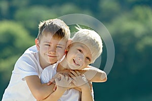 Two little boys are hugging outdoors. Concept of friendship and fraternity