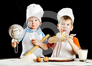 Two little boys making pizza or pasta dough