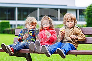 Two little boys and one girl eating chocolate