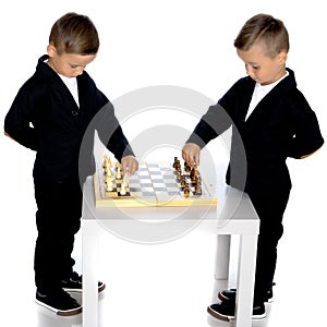 Two little boys play chess.