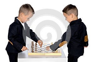 Two little boys play chess.