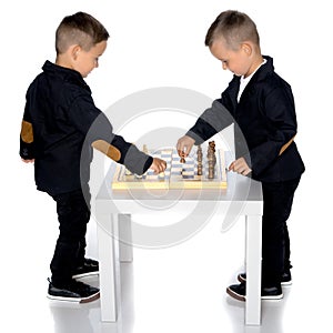 Two little boys play chess.