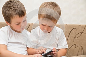 Two little boys playing games on smartphone