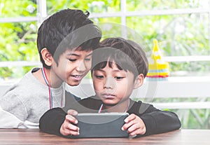 Two boys are playing online game on mobile phone