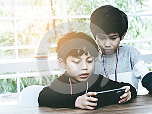 Two Little boys playing online game on mobile phone