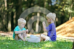 Two Little Boys Playing Outside in Dirt