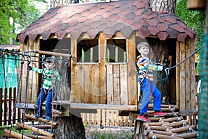 Two little boys playing together and having fun. Lifestyle family moment of siblings on playground. Kids friends play on tree