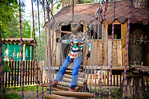 Two little boys playing together and having fun. Lifestyle family moment of siblings on playground. Kids friends play on tree