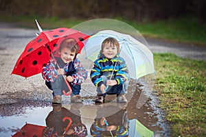 Two little boys with umbrellas