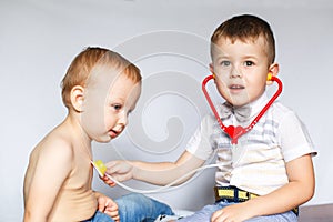 Two little boys using stethoscope. Children playing doctor and patient. Check the heartbeat.