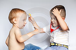 Two little boys using stethoscope. Children playing doctor and patient. Check the heartbeat.
