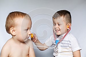 Two little boys using stethoscope. Children playing doctor and patient. Check the heartbeat.