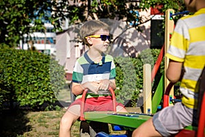 Two little brother toddlers playing with swing balancer