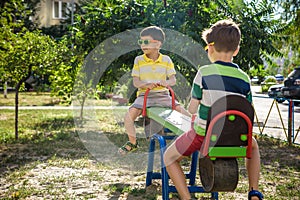 Two little brother toddlers playing with swing balancer