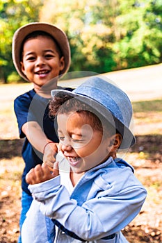 Two little brothers fooling around in nature in park