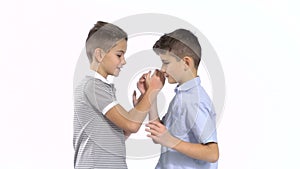 Two little brothers shakes hands at white background