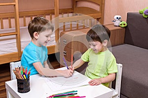 Two little caucasian friends playing with lots of colorful plastic blocks indoor. Active kid boys, siblings having fun building an