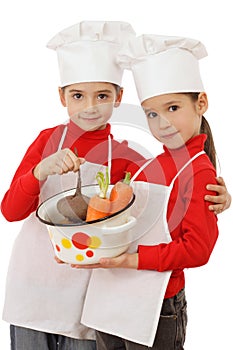 Two little chief-cookers holding a pot