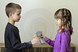 Two little children boy and girl playing with dollars money.