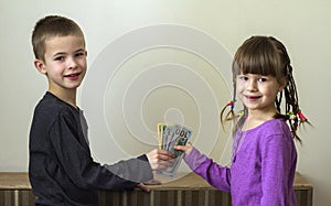 Two little children boy and girl playing with dollars money.