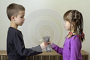 Two little children boy and girl playing with dollars money.