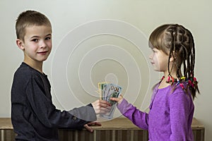 Two little children boy and girl playing with dollars money.