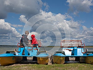 Two little children on a catamaran observing nature
