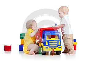 Two little children playing with color toys