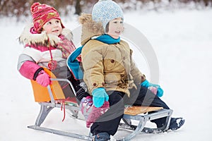 Two little children sit in sled
