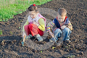 Two little children weed beds