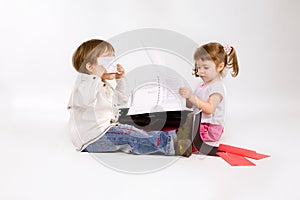 Two little chuldren playing with papers