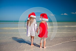 Two little cute girls in Christmas hats have fun