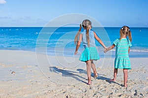 Two little cute girls enjoy their summer vacation on the beach