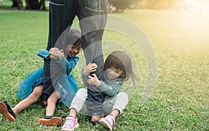 Two little daughter having fun together with her father