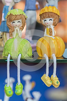 Two little dolls in a shop window. vertical photo