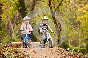 Two little friends sitting on balancing bikes