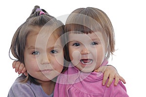 Two little girl hugging portrait isolated on white background. happy siblings different age together